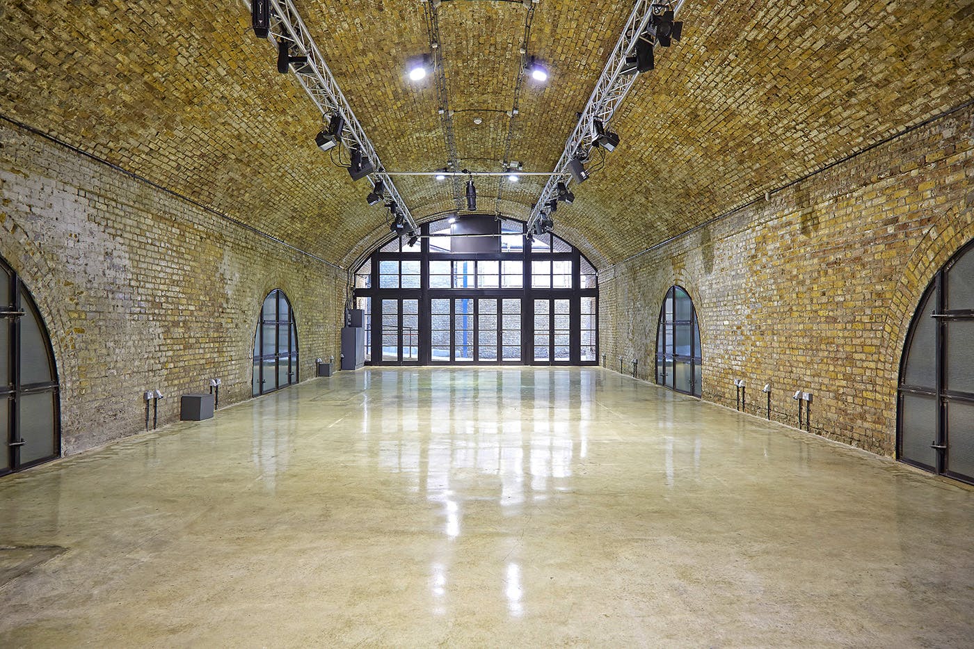 Spacious industrial event venue with exposed brick walls, ideal for weddings and conferences.