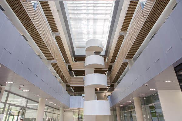 Modern auditorium atrium with spiral staircase, ideal for conferences and networking events. - Banner
