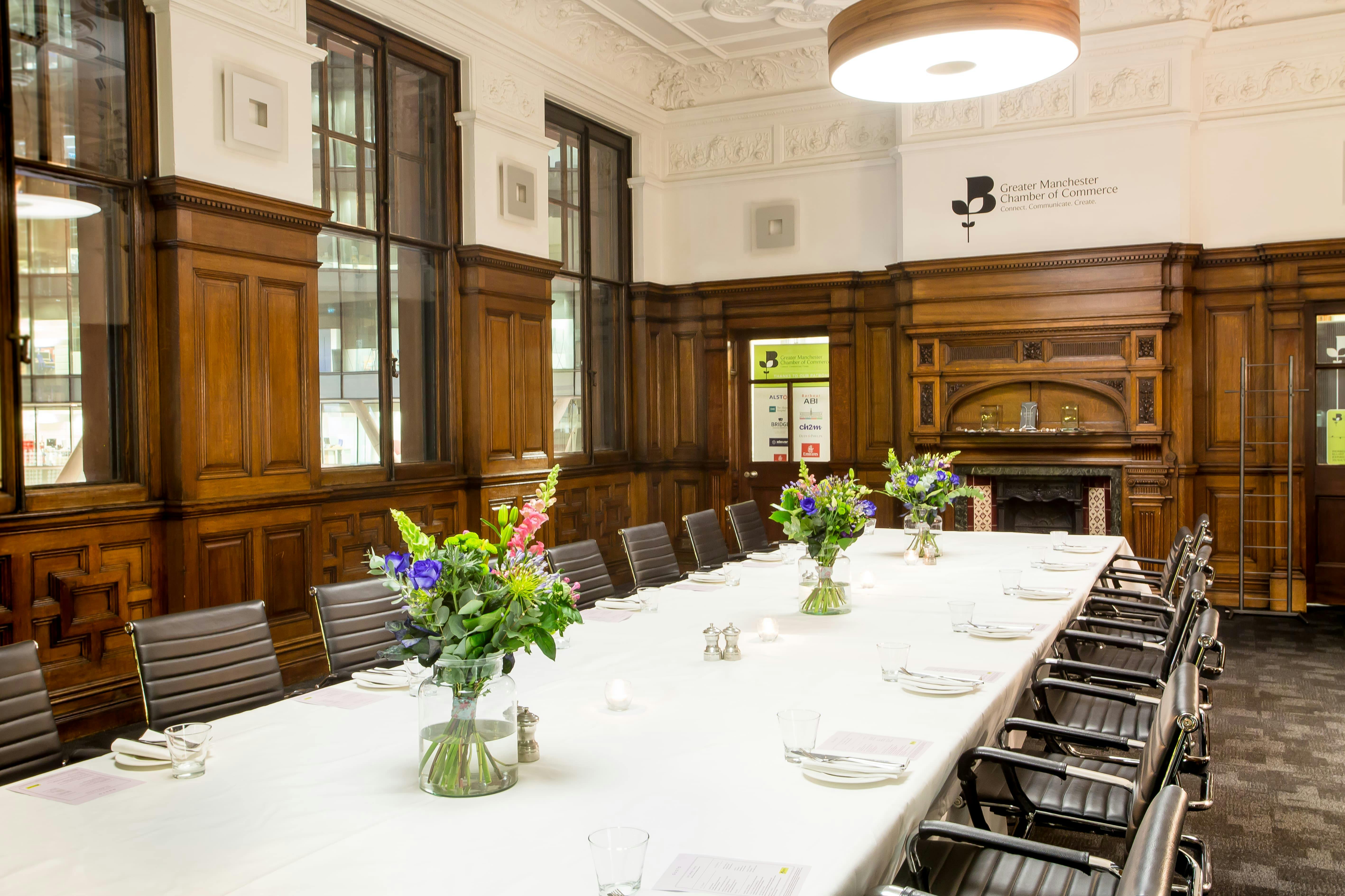 Elegant boardroom with floral arrangements, ideal for professional meetings and events.