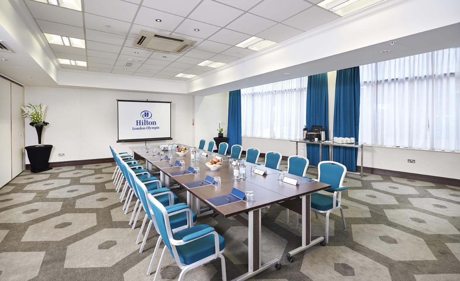 Hilton London Olympia meeting room with blue chairs, perfect for professional events.