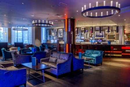 Modern lounge at Society Bar, Hilton London Olympia, ideal for networking events and meetings.