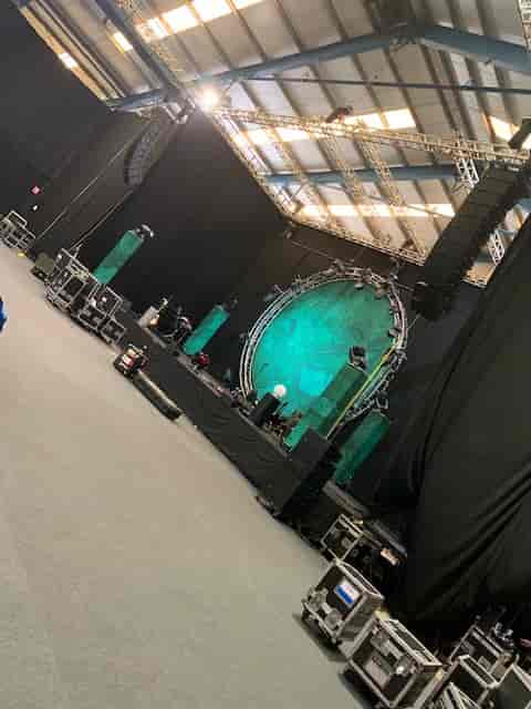 Showering Pavilion stage setup with green backdrop for live event at Bath & West Showground.