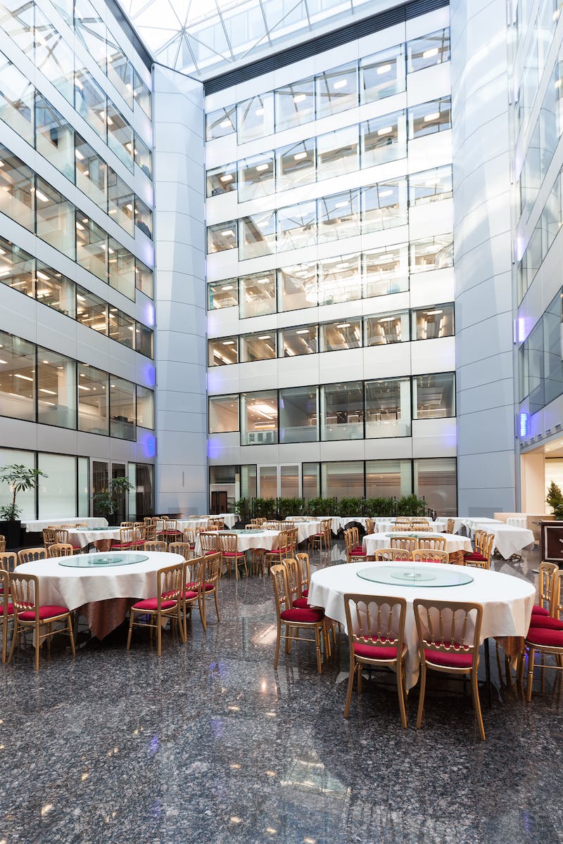 Modern atrium with round tables, ideal for events and networking in Bright Courtyard Club.