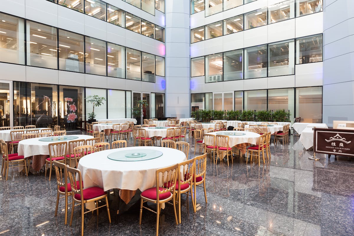 Spacious modern event space with round tables, ideal for corporate events and receptions.