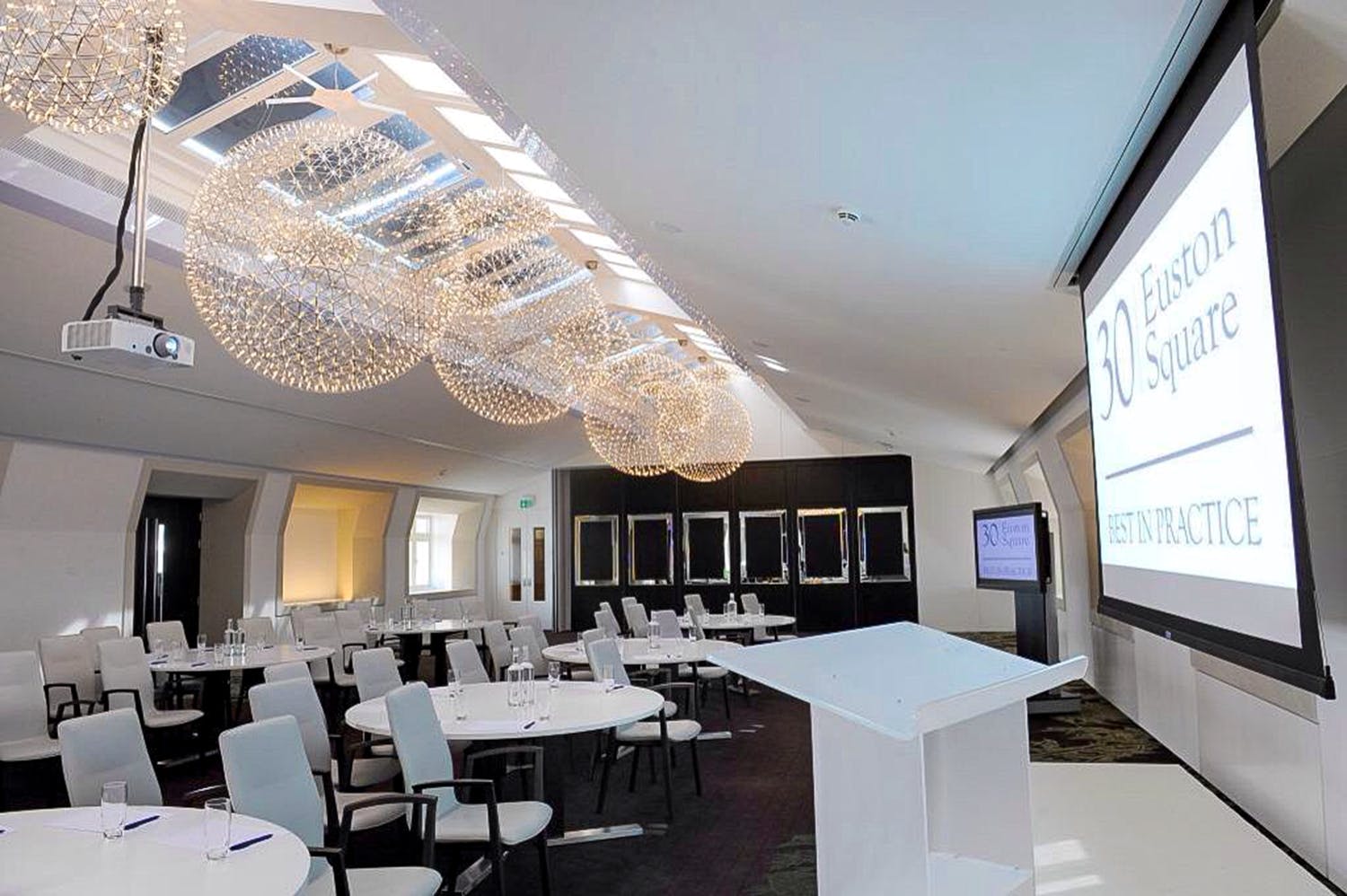 Modern event space with elegant chandeliers for meetings and presentations at 30 Euston Square.