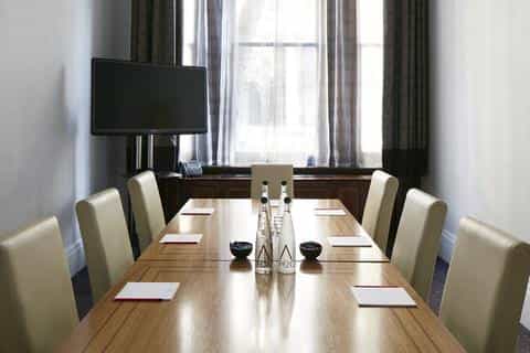 Private dining room with polished wooden table, ideal for corporate meetings and events.