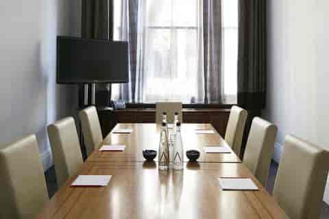Private dining room with wooden table and leather chairs for meetings at Trafalgar Square.