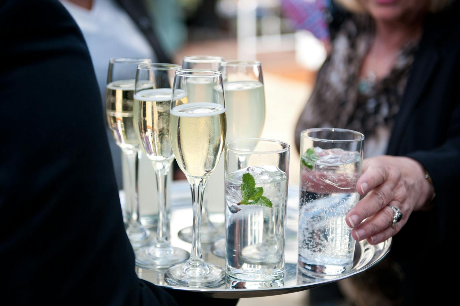 Elegant champagne flutes and refreshing water on a polished tray at Ravens Ait Island reception.