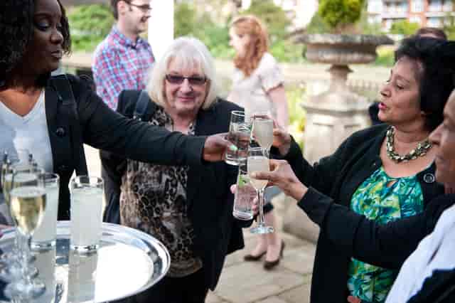 Lively networking event on Ravens Ait Island with attendees toasting outdoors.