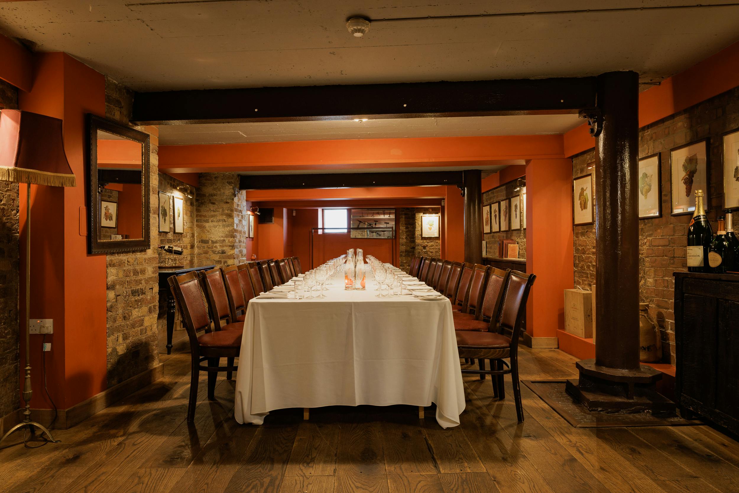 Elegant wine cellar meeting room with long table, ideal for corporate events and gatherings.