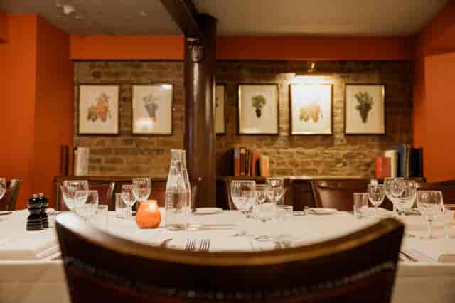 Elegant dining table in cozy Wine Cellar Room for private events and corporate dinners.