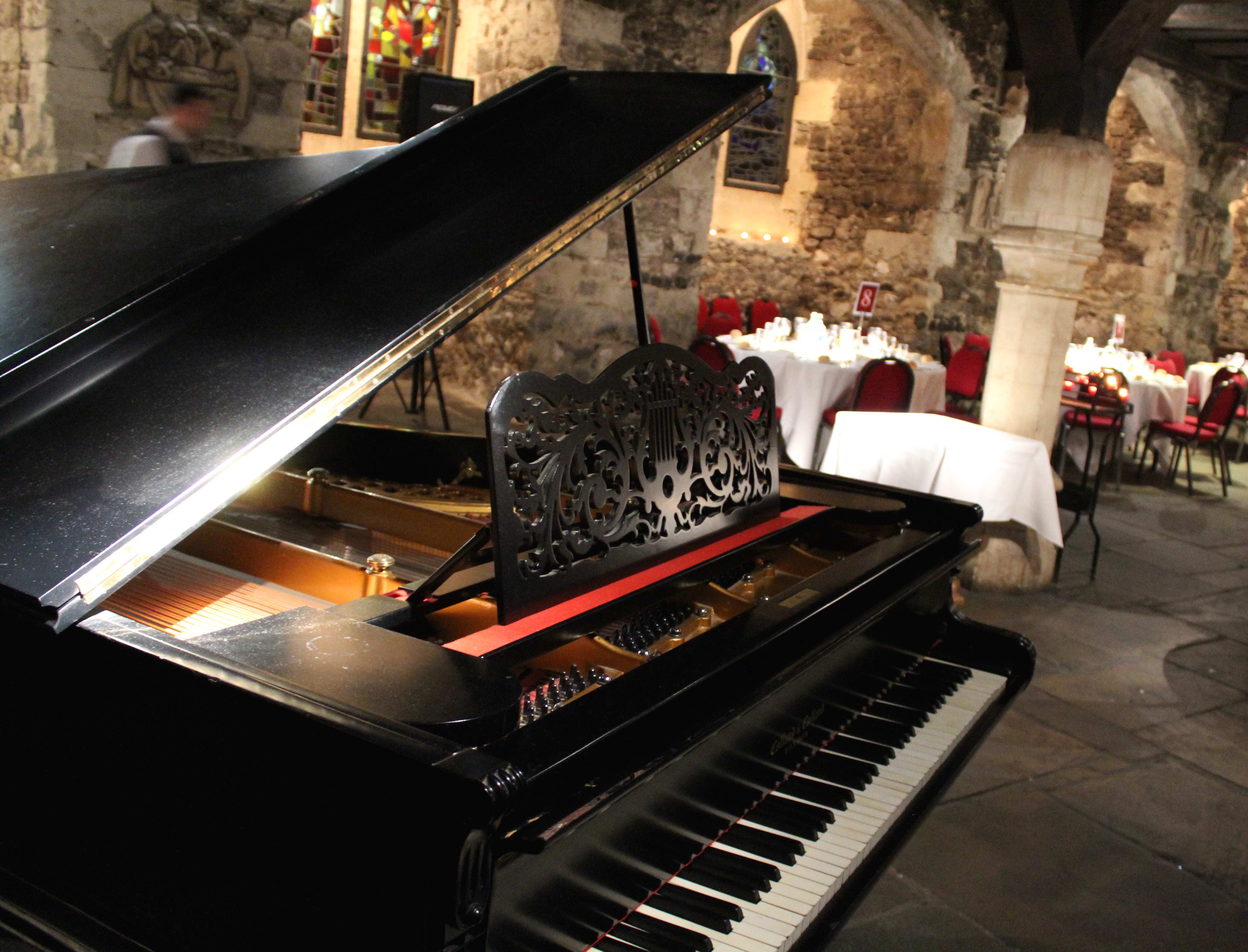 Elegant event space in The Crypt with grand piano, ideal for live music and gatherings. - Banner