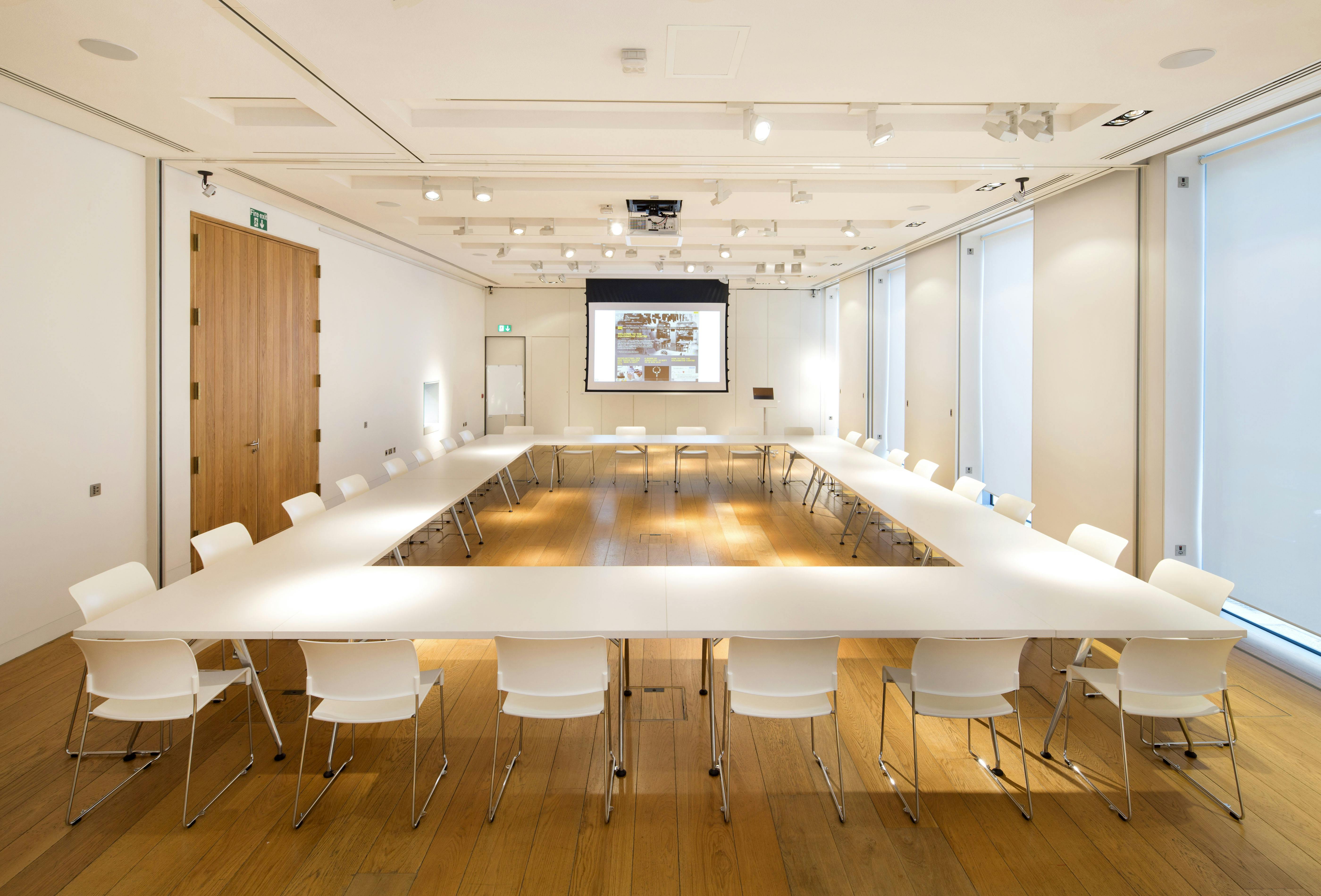 Modern meeting room with large table, ideal for workshops and strategic planning.