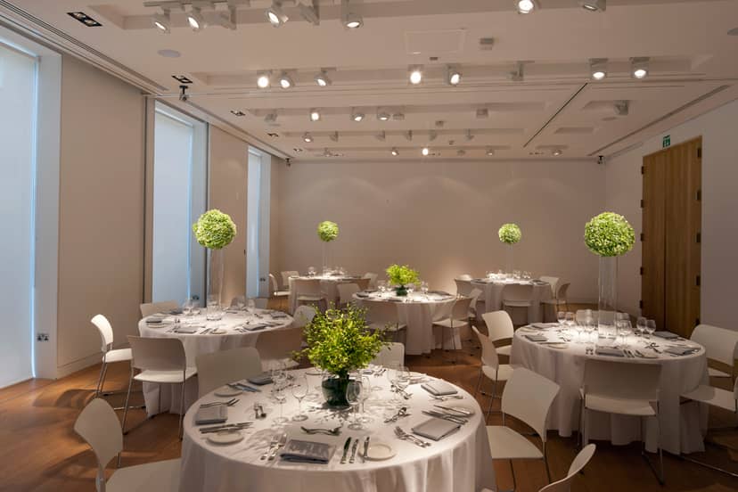 Elegant exhibition room with round tables, ideal for corporate events and weddings.