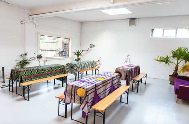 Spacious venue with vibrant tables, perfect for workshops and gatherings.