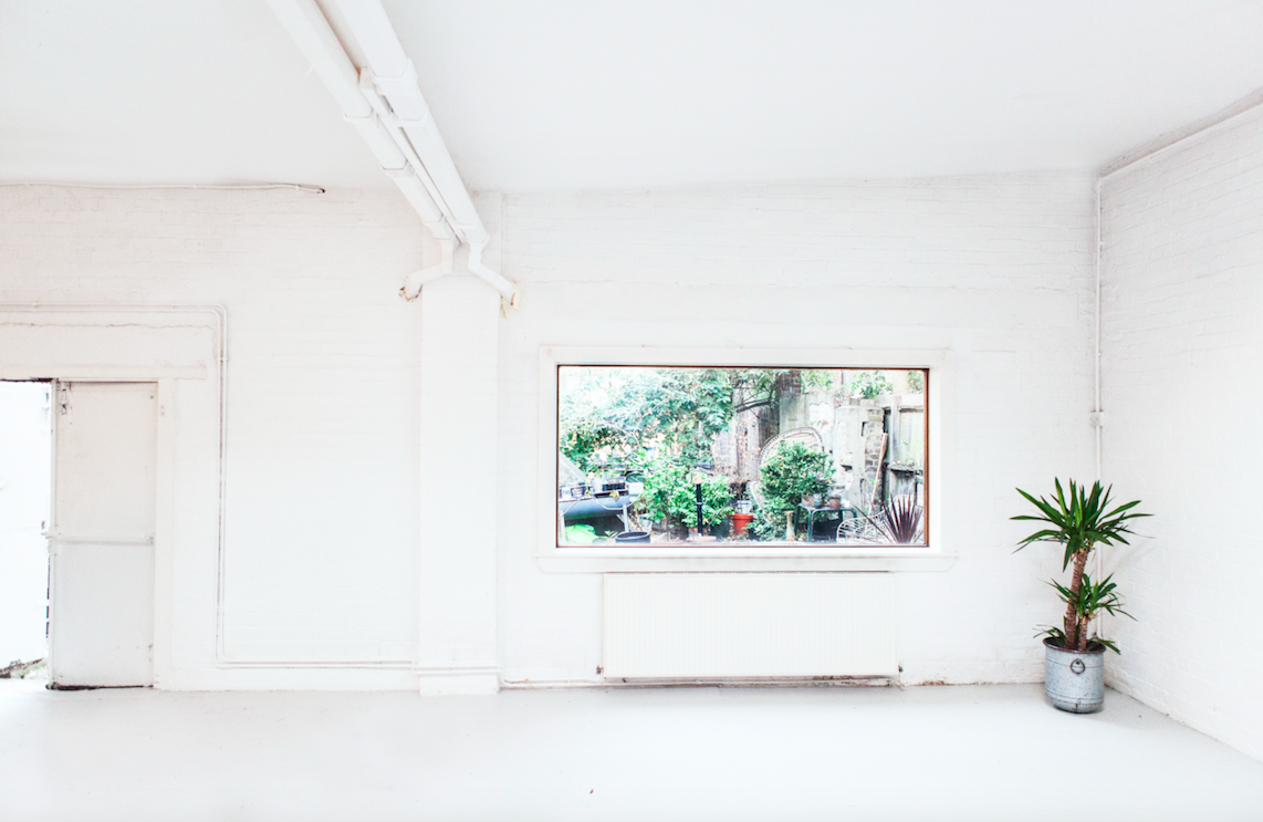 Bright minimalist studio with large windows, perfect for workshops and meetings. - Banner