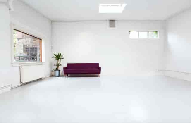 Versatile meeting studio with natural light, ideal for workshops and events.