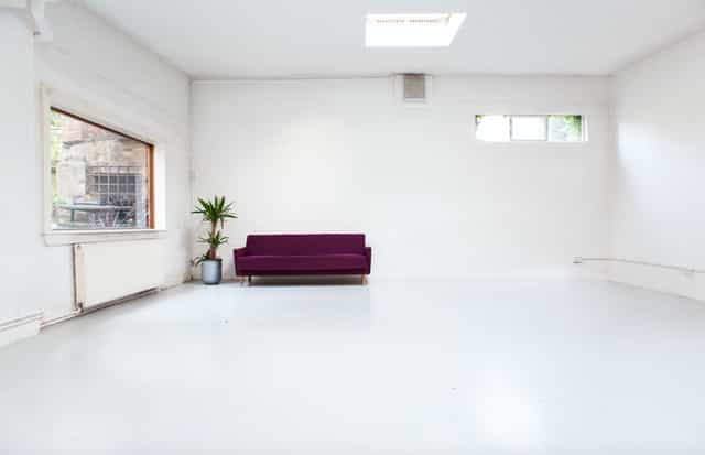 Versatile meeting studio with natural light, ideal for workshops and events.