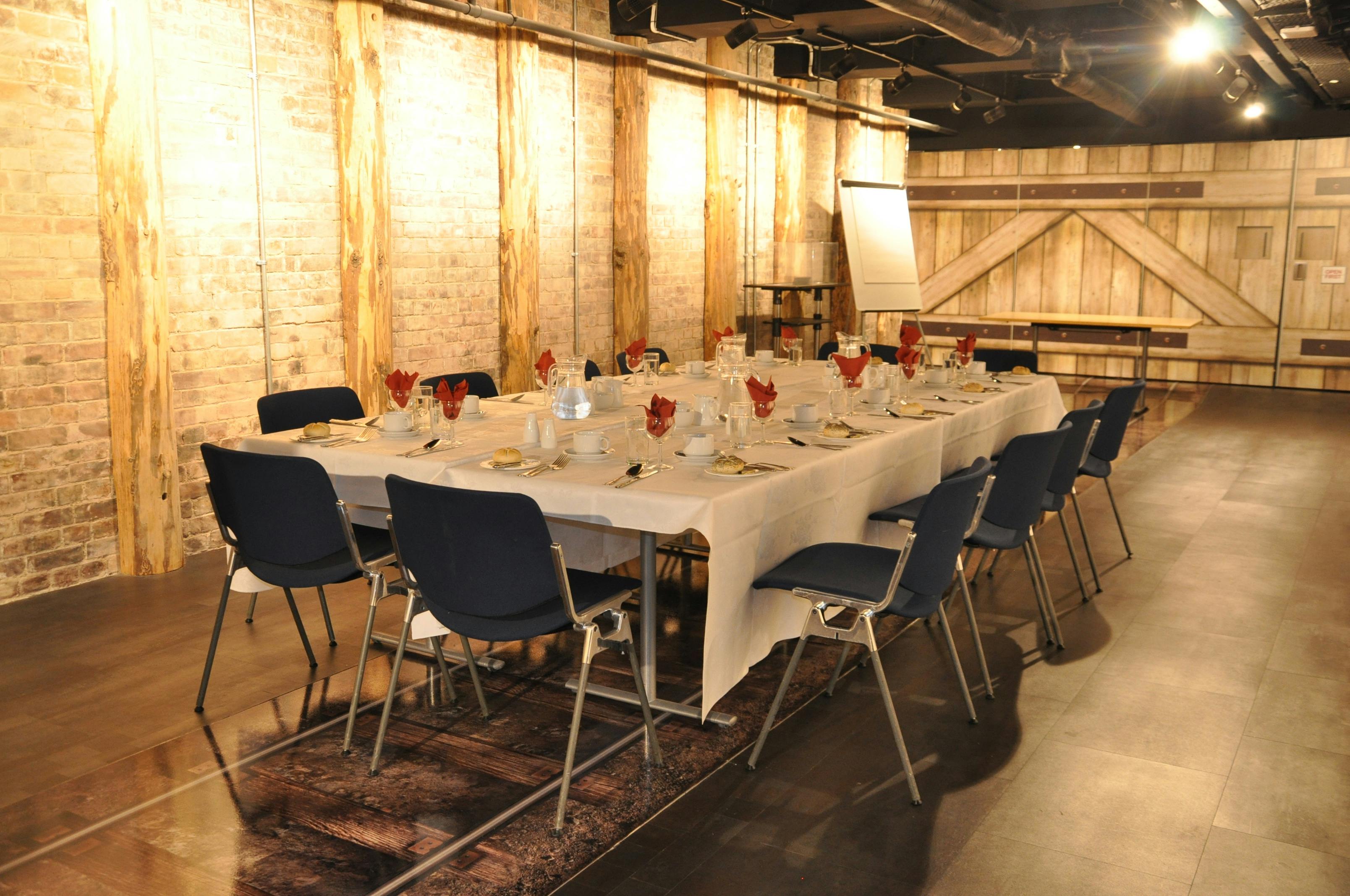 Elegant dining table in rustic venue, perfect for corporate events and intimate gatherings.