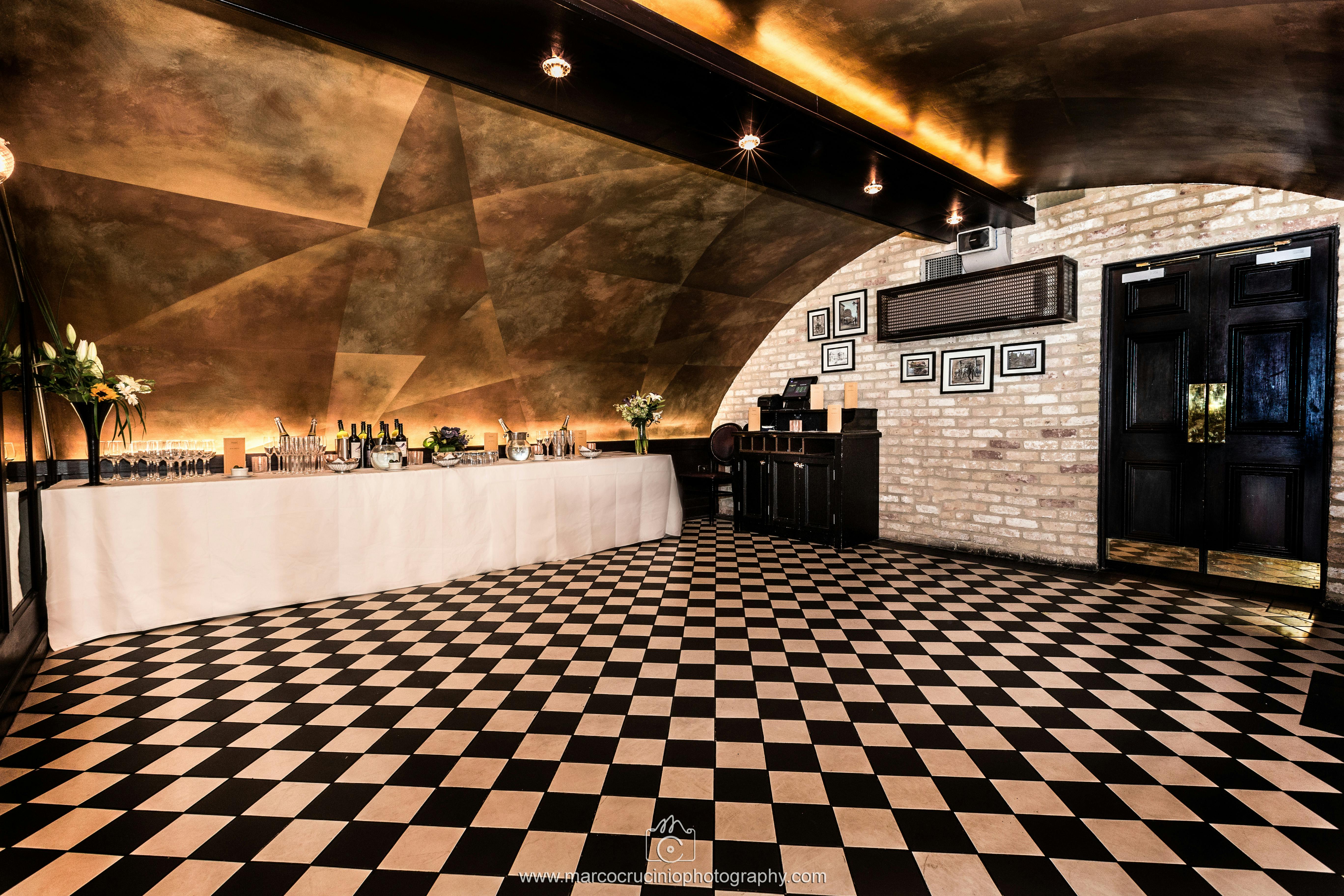 Elegant event space with checkered floor, ideal for networking and cocktail receptions.