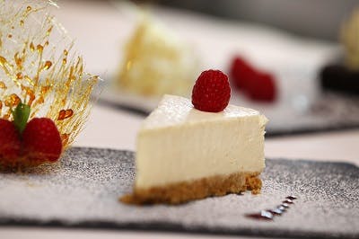 Serengeti Suite cheesecake with raspberries, perfect for upscale events and celebrations.