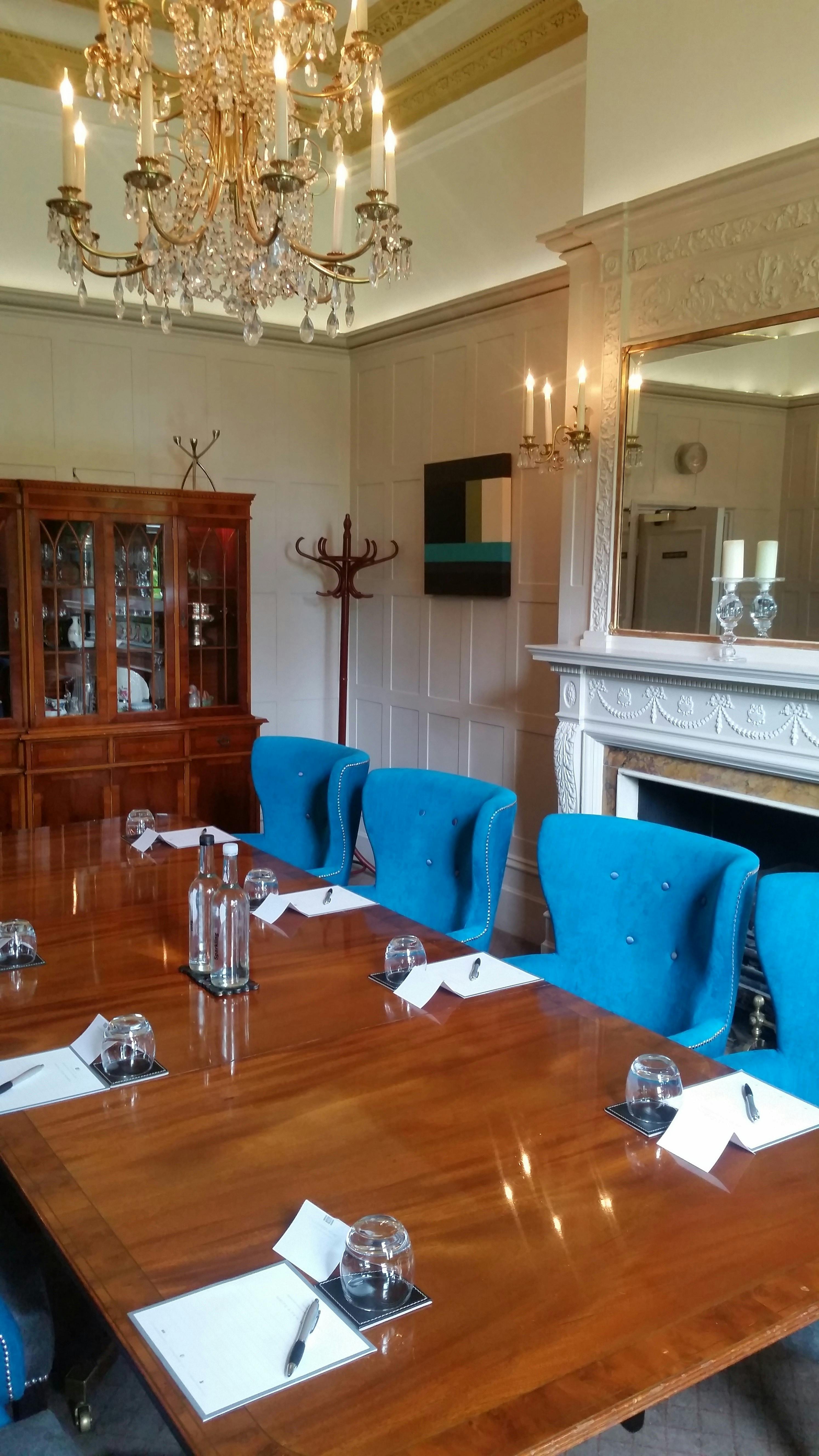 Asquith Suite meeting room with polished table and blue chairs, perfect for corporate events.