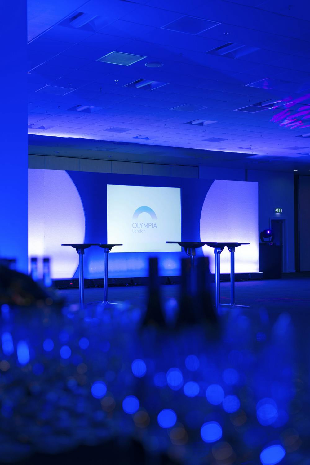 East Hall in Olympia London with a well-lit stage, ideal for corporate events and conferences.