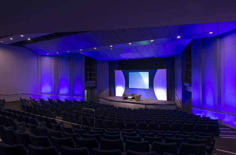 Modern conference auditorium in Olympia London with blue lighting for impactful presentations.