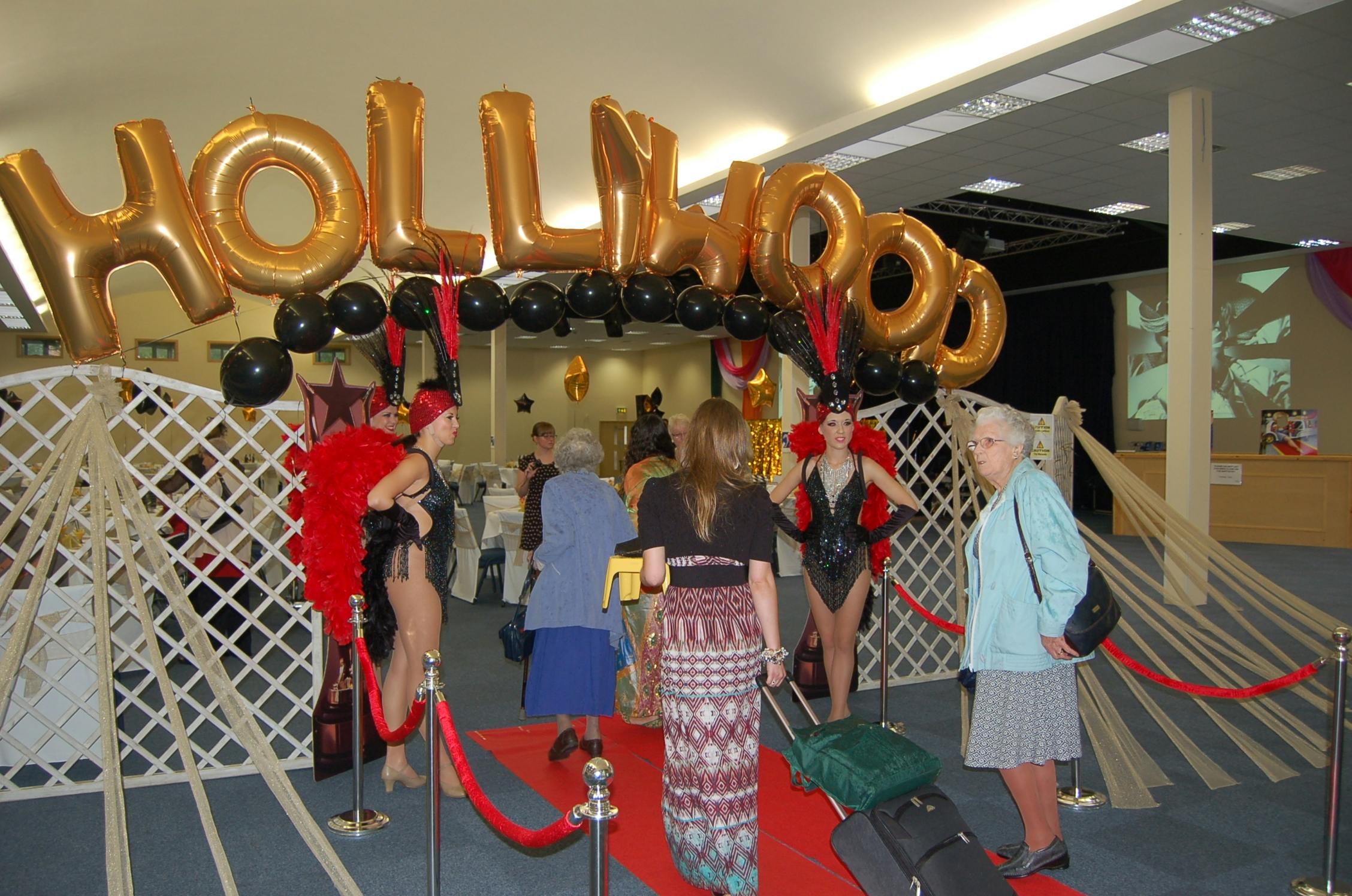 Thames Hall Hollywood-themed event entrance with gold balloons and red carpet.