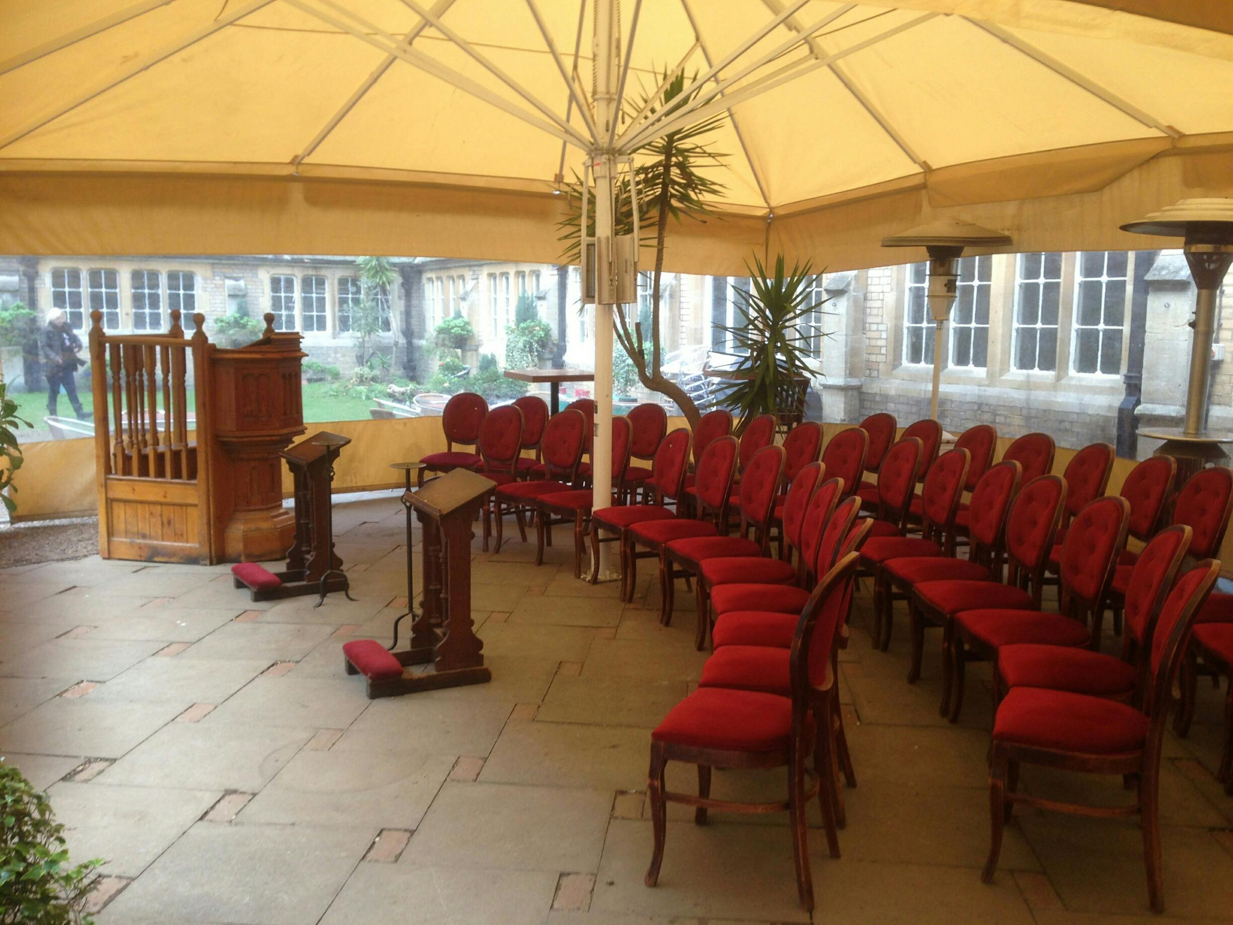 Elegant outdoor event space with red chairs, perfect for weddings and corporate gatherings.