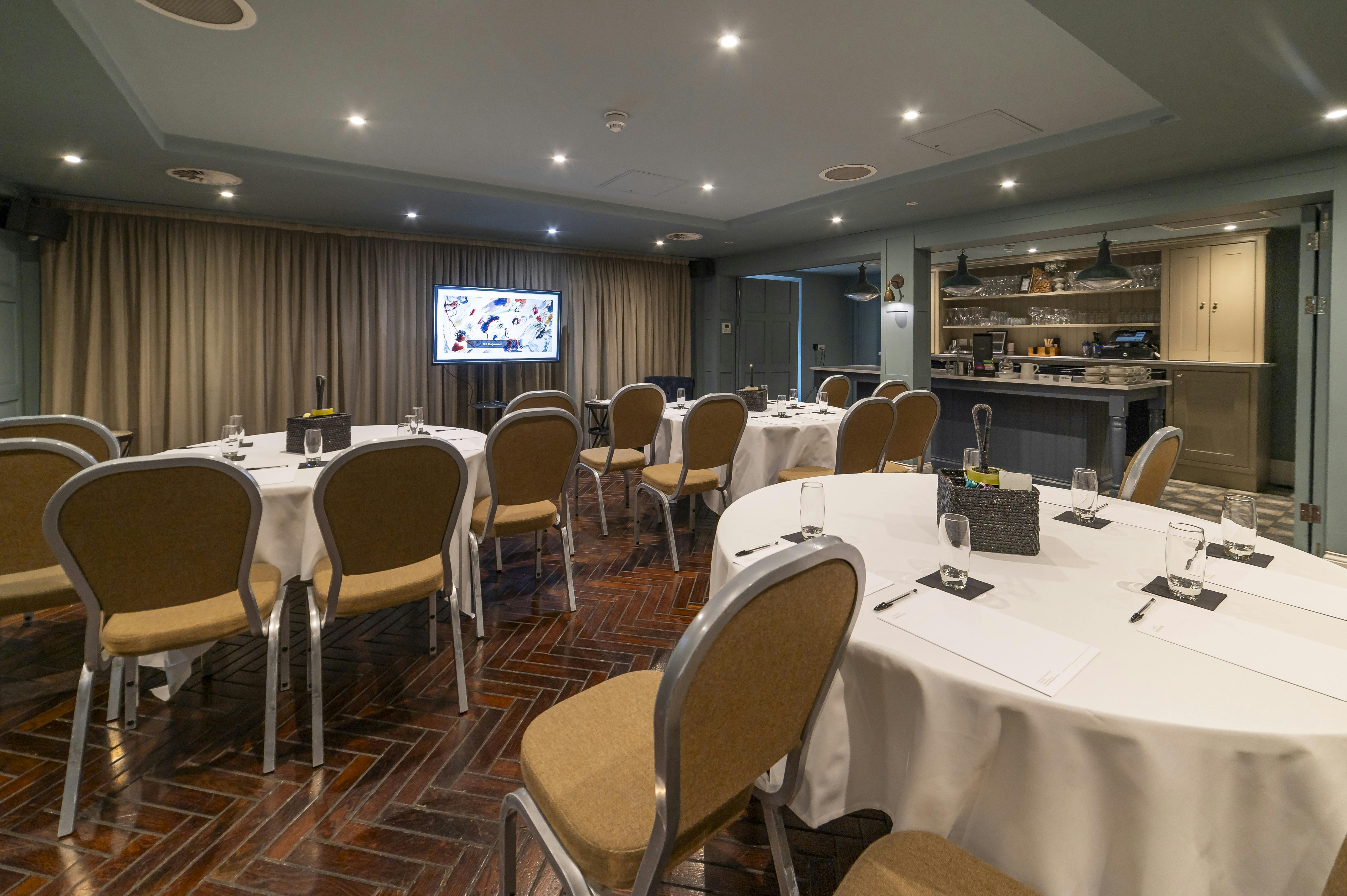 Meeting room at King Street Townhouse with round tables, ideal for corporate events.