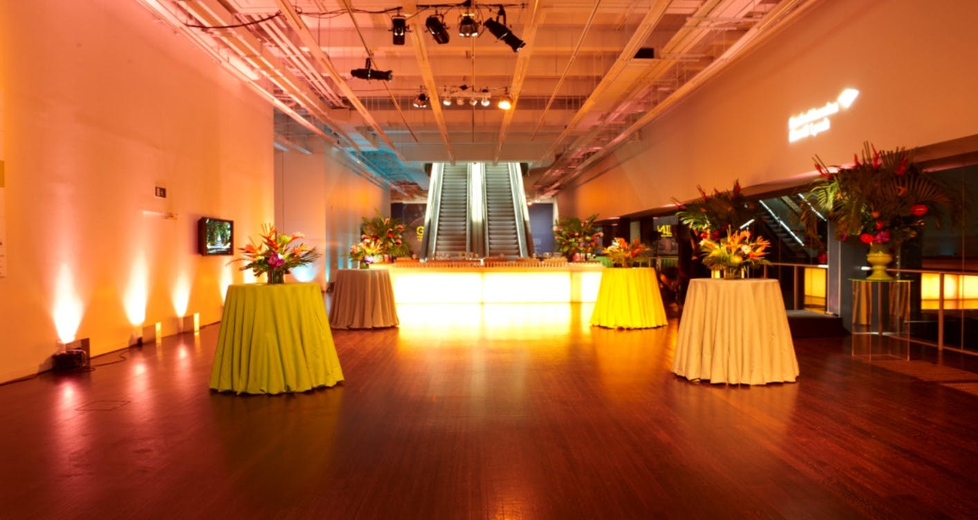 Elegant cocktail tables with floral arrangements in Tate Modern event space.