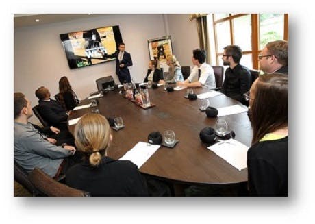 Boardroom meeting at Chessington Resort with oval table and presentation screen.