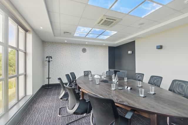 Modern meeting room with oval table, ideal for workshops and strategic planning.