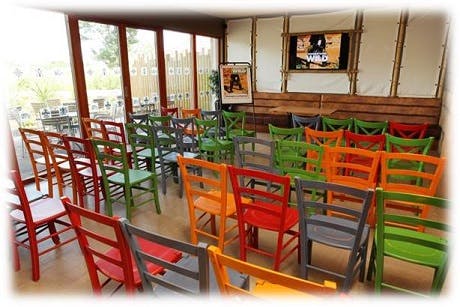 Vibrant meeting space with colorful chairs at Temple Restaurant, ideal for workshops.