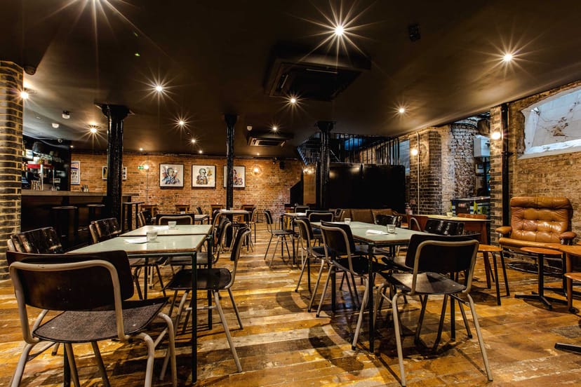 Basement Bar: warm industrial event space with exposed brick, ideal for gatherings and workshops.