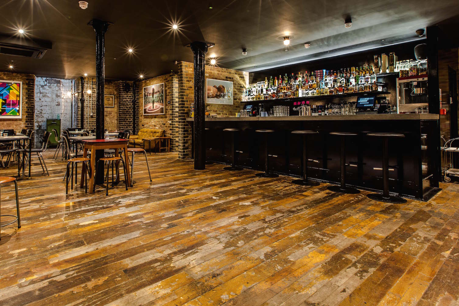 Basement Bar with exposed brick, ideal for networking events and casual gatherings. - Banner