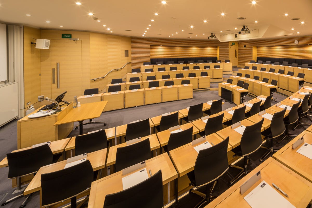 Rhodes Trust Lecture Theatre at Saïd Business School, modern conference room with tiered seating.
