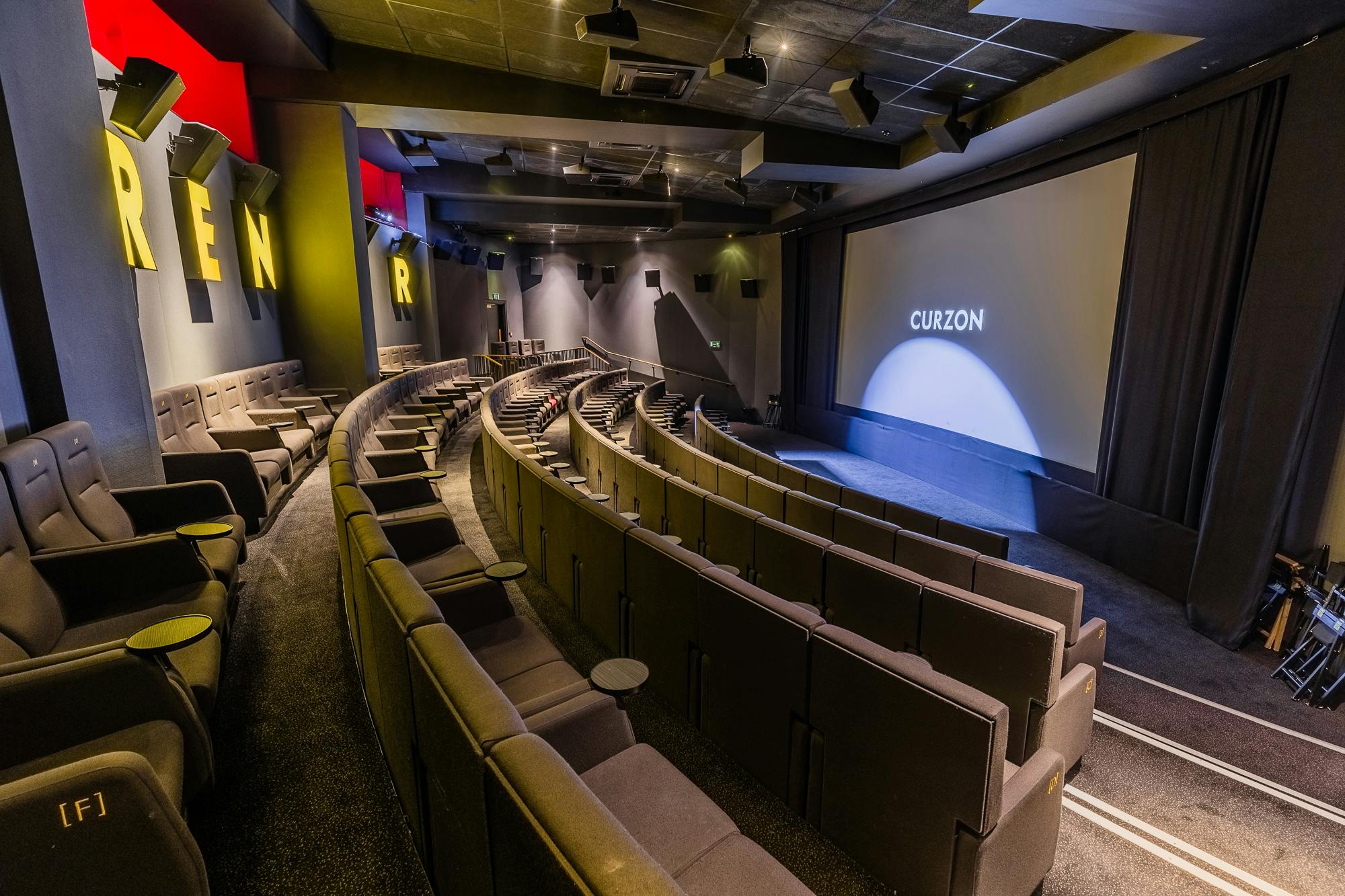 Modern tiered cinema with plush seating for film premieres and private screenings.