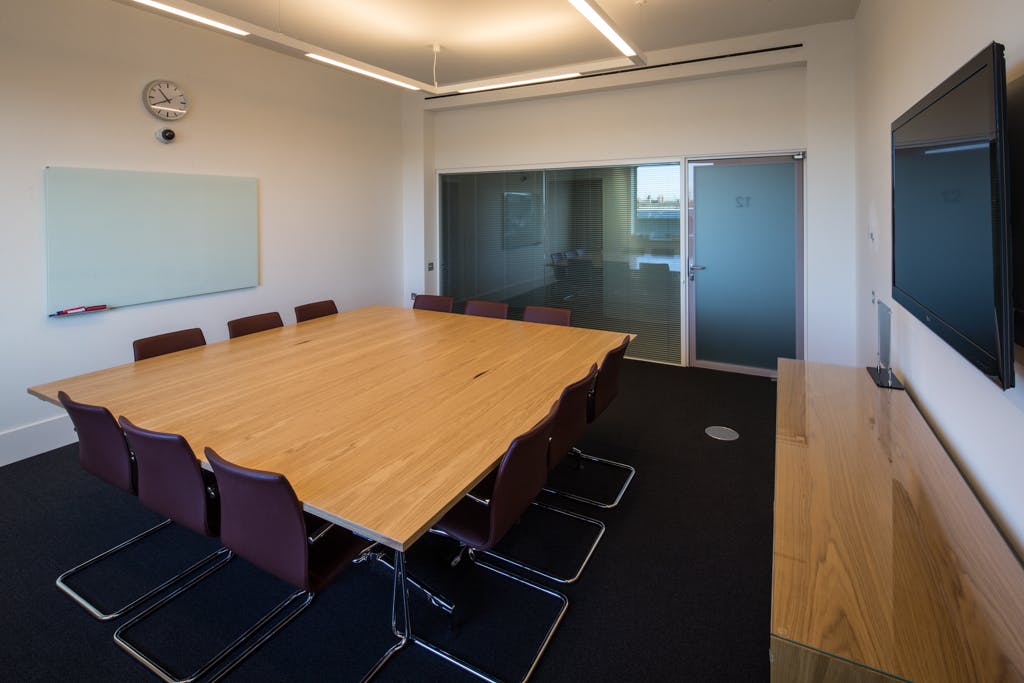 Modern conference room with large wooden table at Saïd Business School, Oxford for meetings.