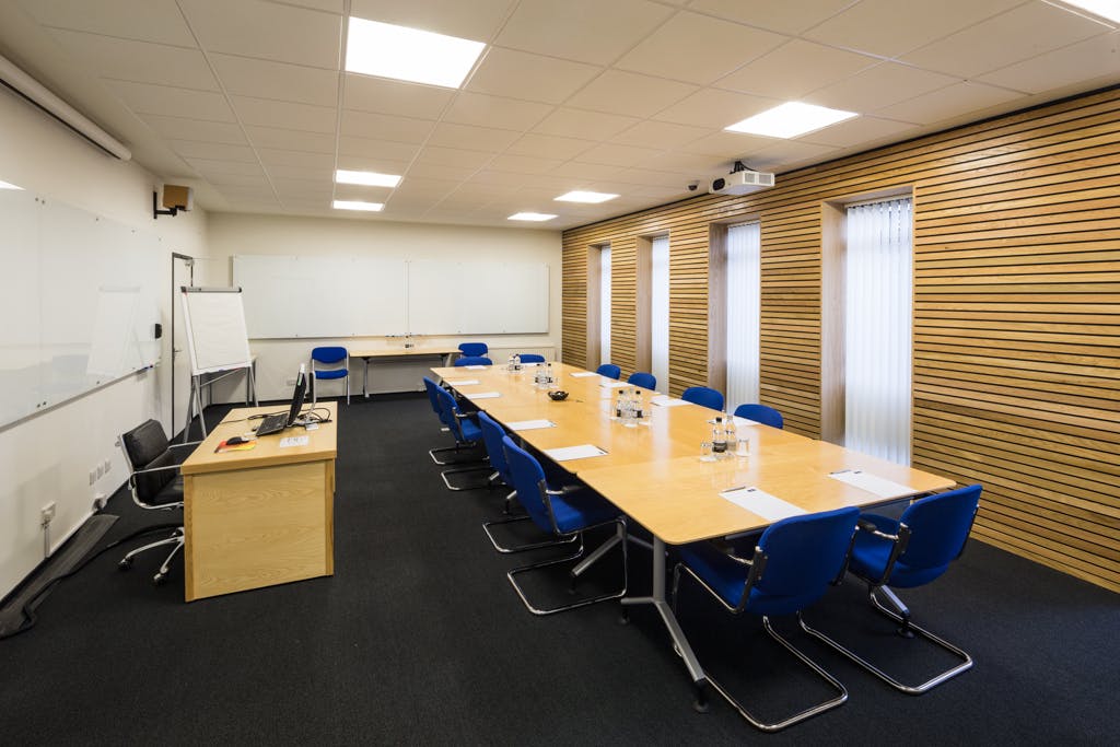 North West Room at Egrove Park, Oxford: modern meeting space with natural light and AV setup.