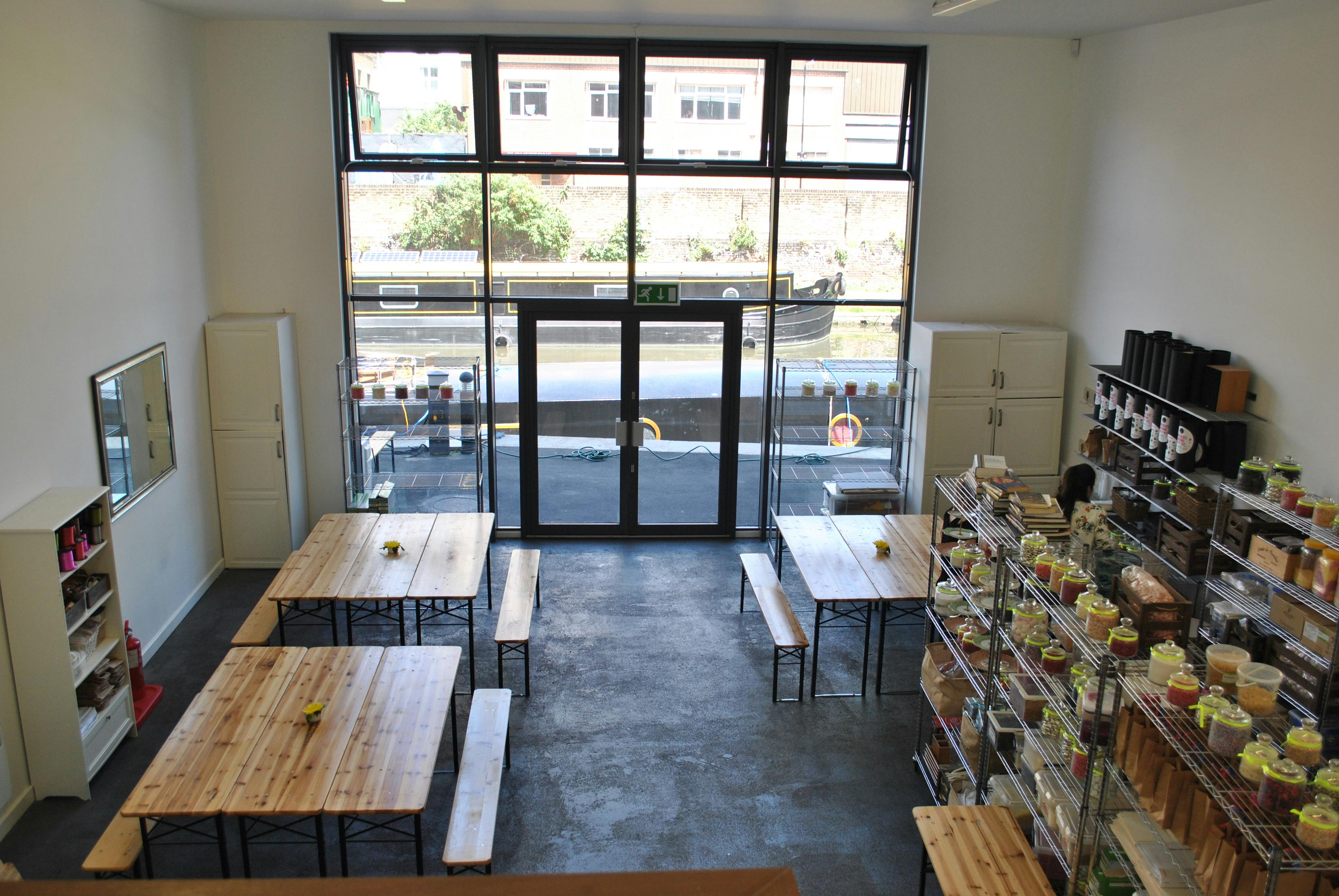 Spacious workshop venue with wooden tables and natural light for events and meetings.