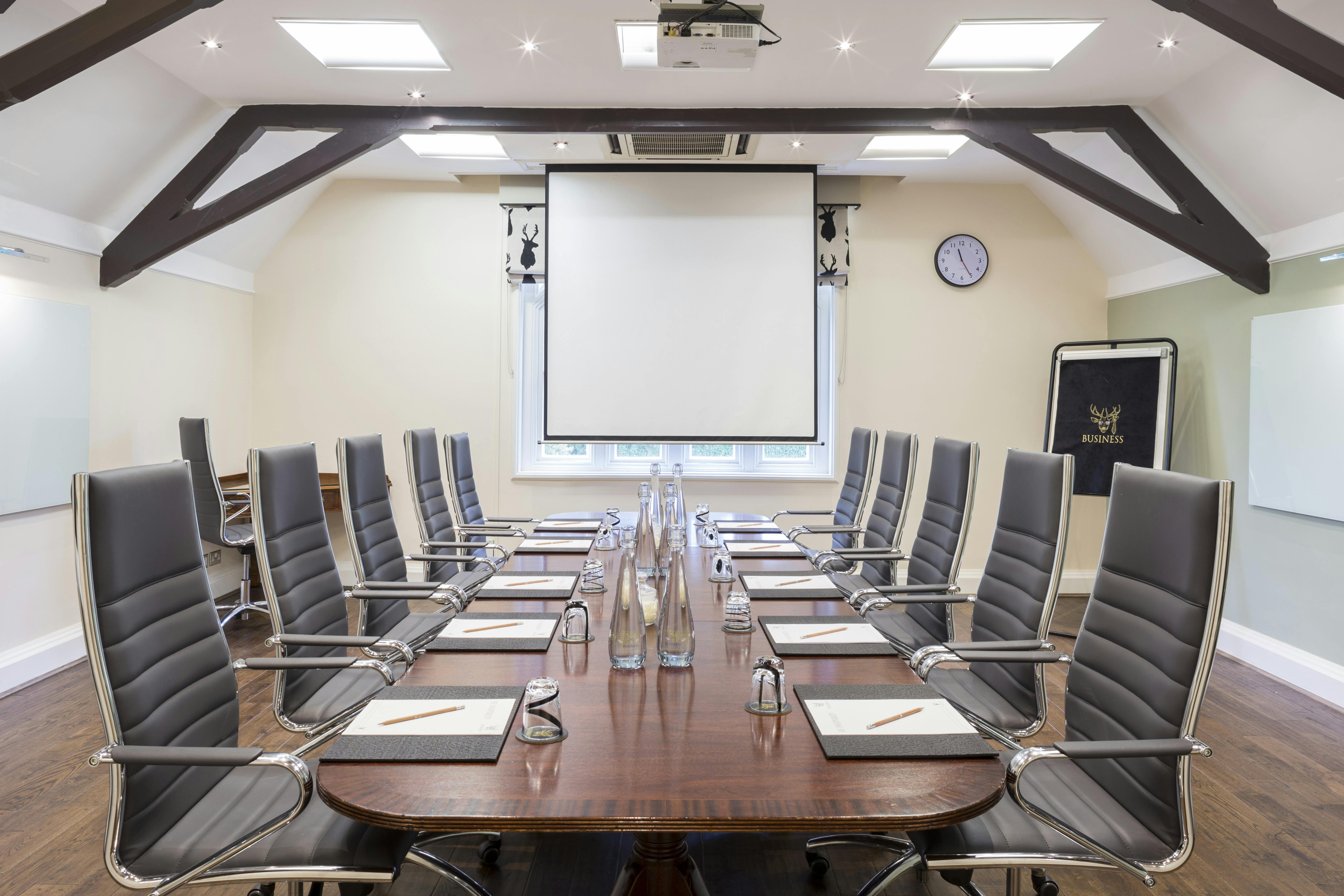 Kingston Suite conference room with wooden table, ideal for professional meetings and presentations.