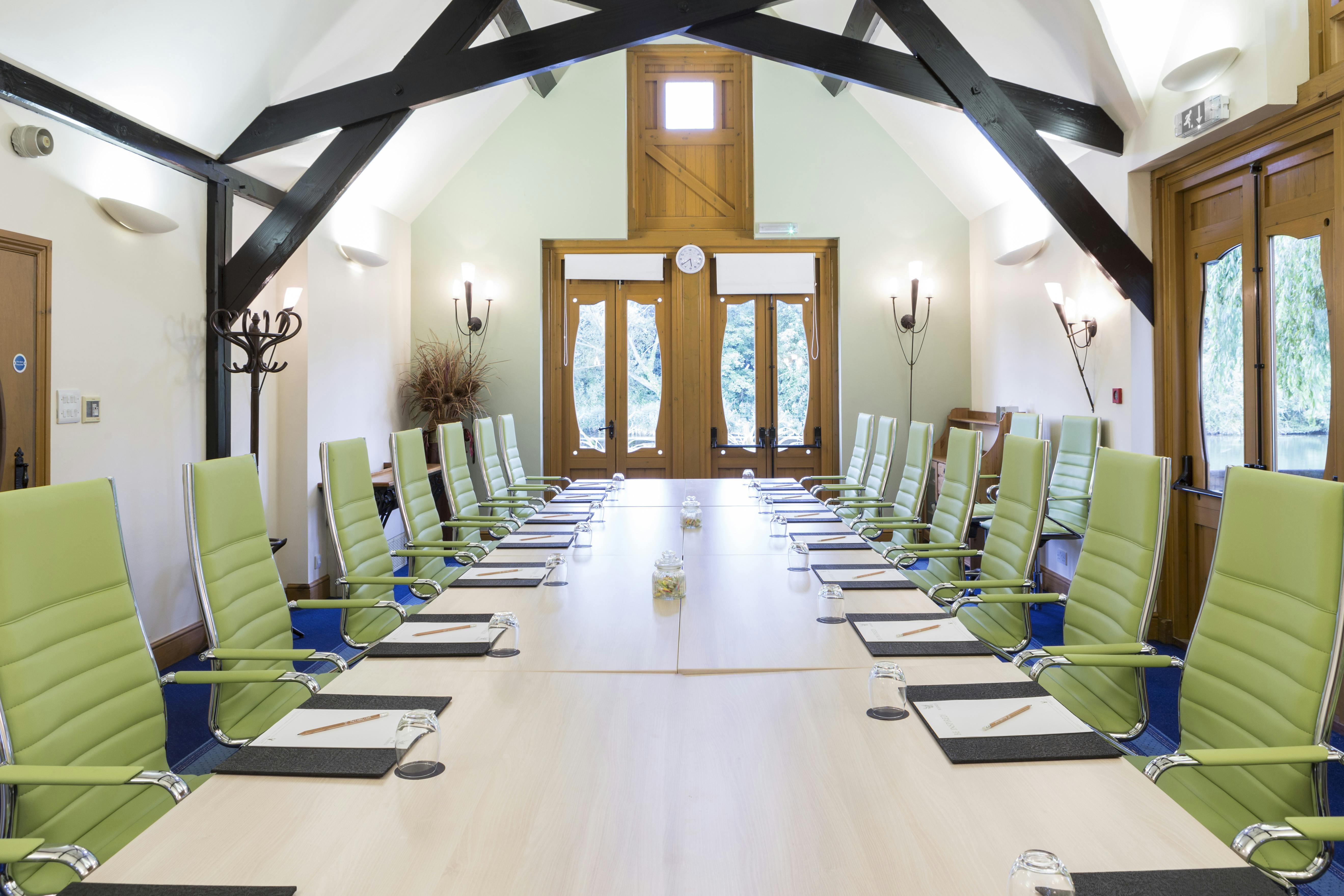 Modern conference room at The Boathouse, featuring green chairs for events and meetings.