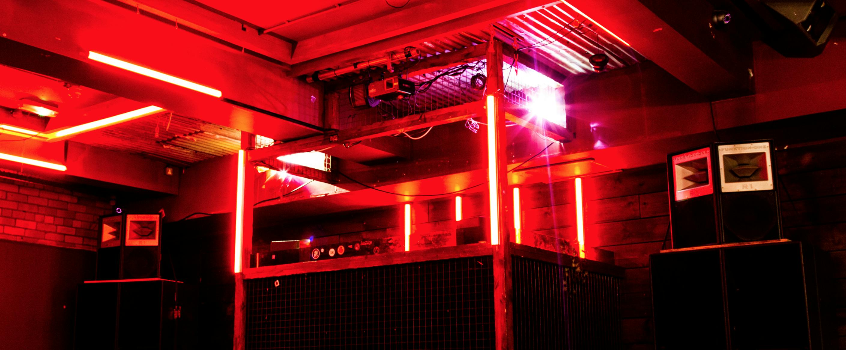 Vibrant event space at Brickhouse Social with red lighting for nightlife gatherings.