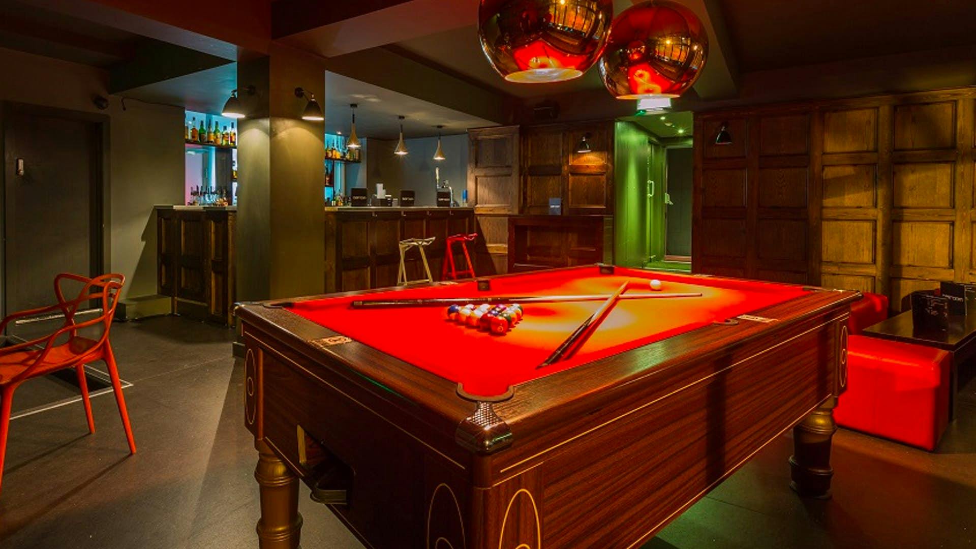 Stylish lounge with red pool table for networking at Brickhouse Social events.