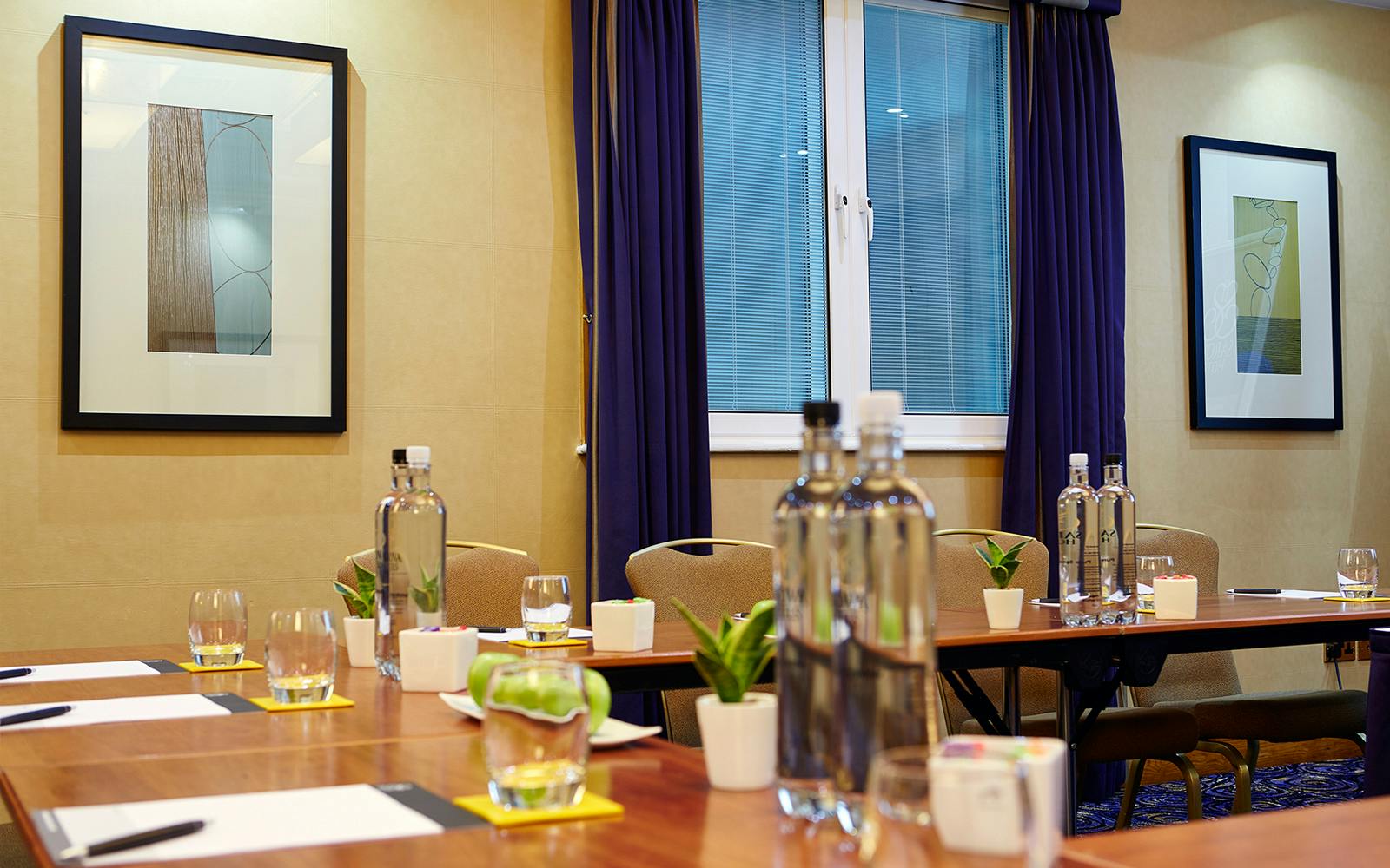 Queens Suite meeting room with polished wooden table, ideal for corporate events.