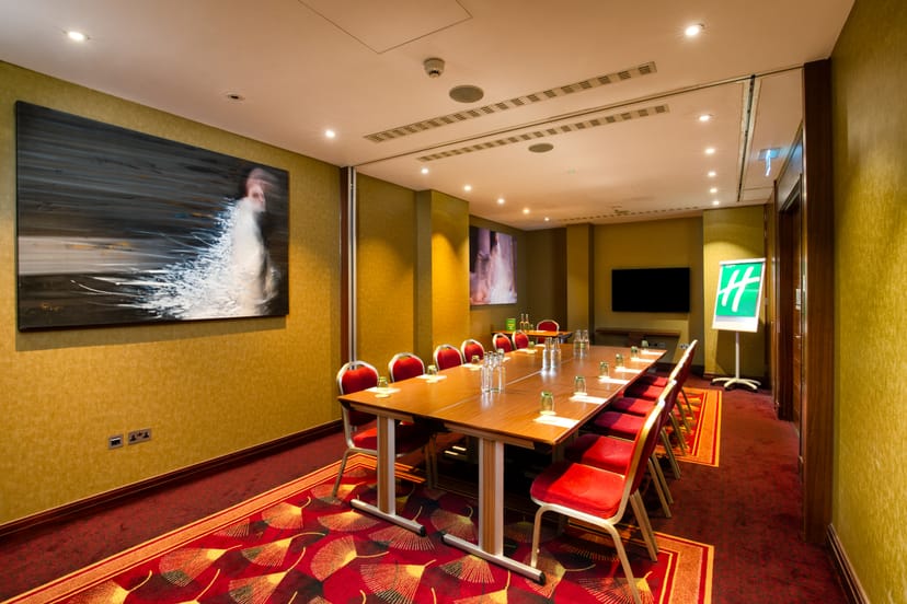 St James Suite in Holiday Inn Kensington, polished table and red chairs for corporate meetings.