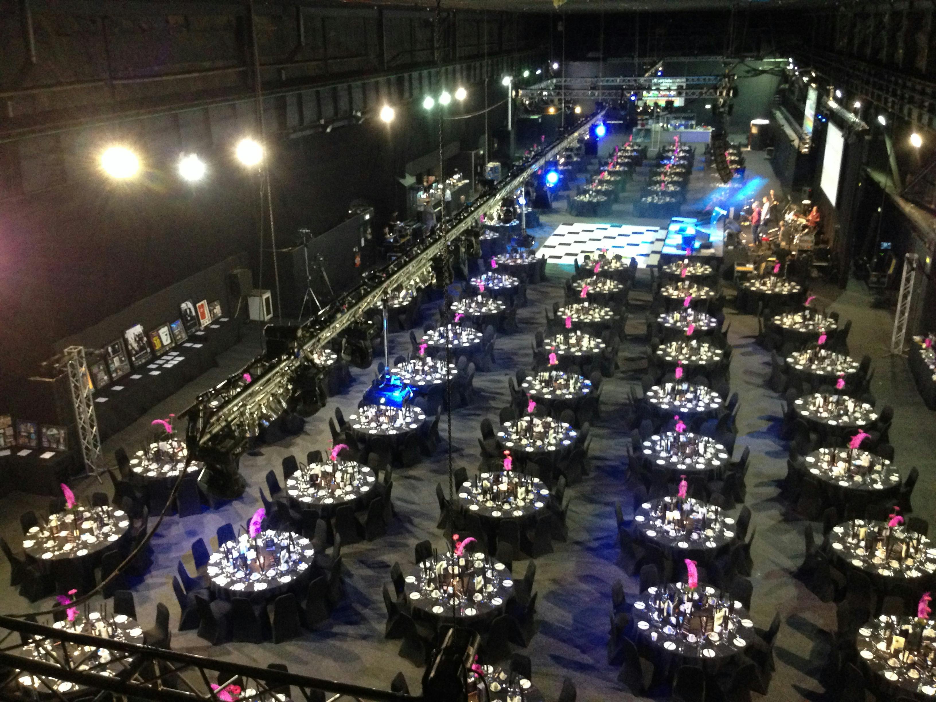 Elegant event space in The Big Hall, MAGNA, with black tables and pink centerpieces.