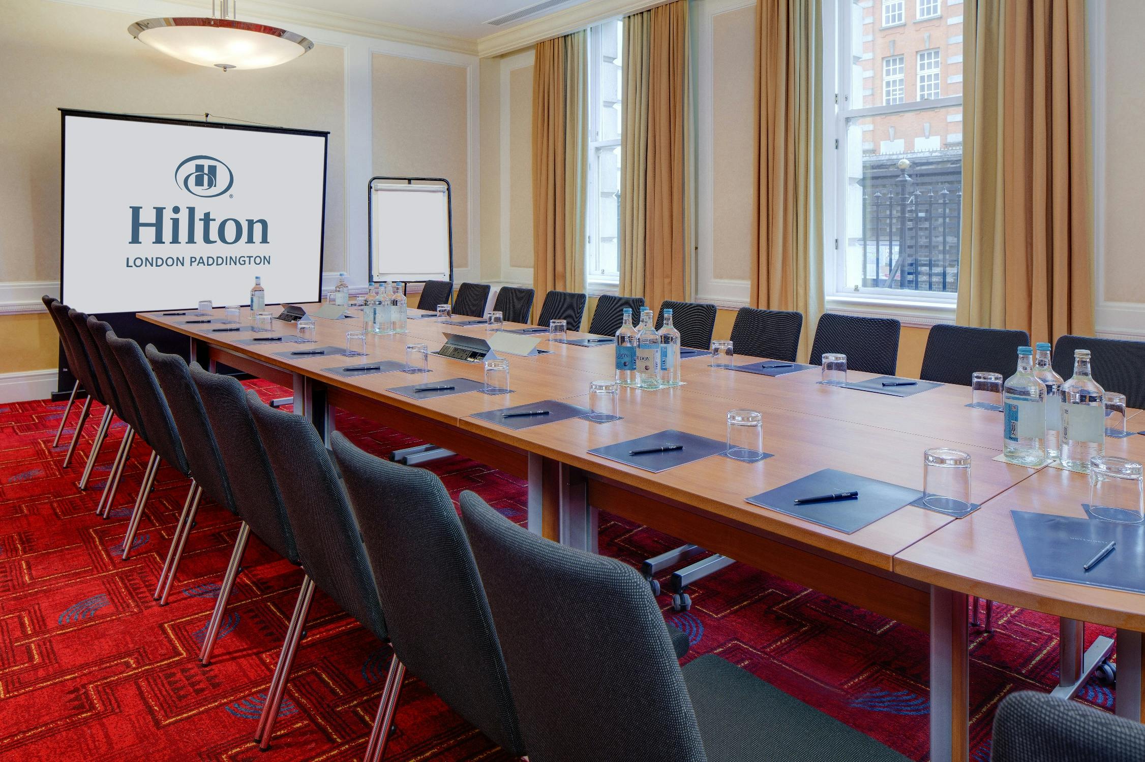 Meeting room at Hilton London Paddington with conference table for corporate events.